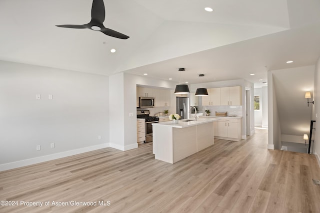 kitchen featuring appliances with stainless steel finishes, sink, a center island with sink, decorative light fixtures, and white cabinetry