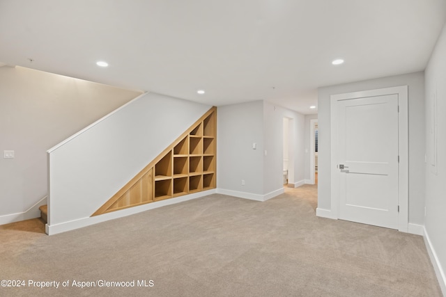 interior space with built in features and light colored carpet