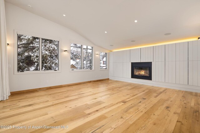 unfurnished living room featuring light hardwood / wood-style floors and lofted ceiling