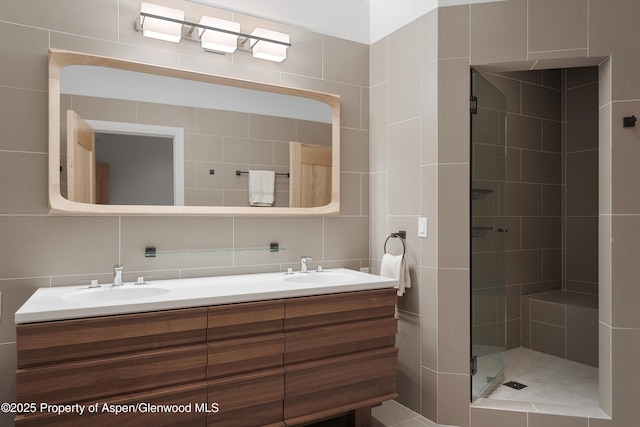 bathroom with an enclosed shower, vanity, tasteful backsplash, and tile walls