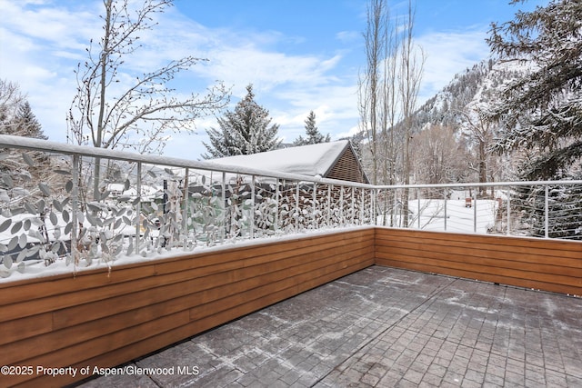 snow covered patio with a balcony