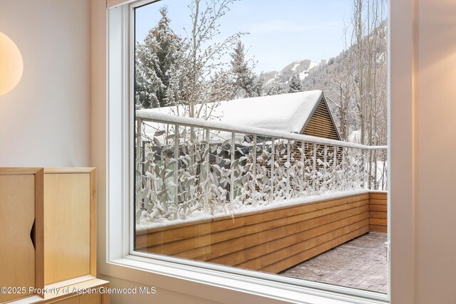 snow covered back of property with a mountain view