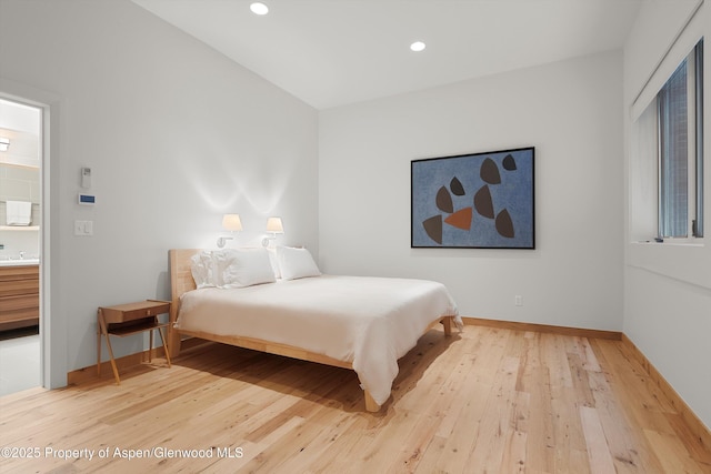 bedroom with hardwood / wood-style flooring and sink