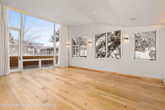 unfurnished living room featuring light hardwood / wood-style flooring and lofted ceiling