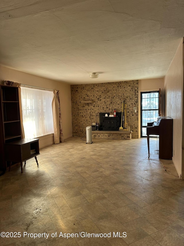 unfurnished living room with brick wall and a fireplace