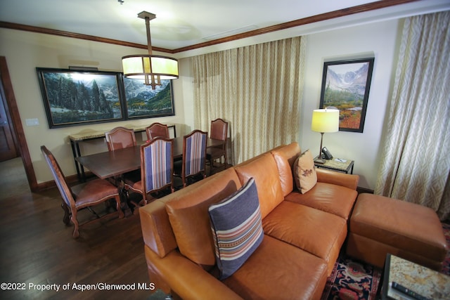 living room featuring dark hardwood / wood-style flooring, ornamental molding, and an inviting chandelier