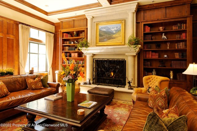 living area with built in features and ornamental molding