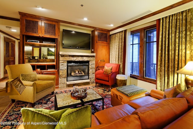 living room with a stone fireplace and ornamental molding