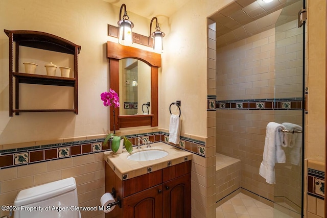 bathroom with vanity, tile walls, and toilet