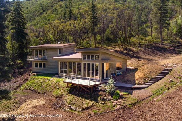 768 Kings Lake Rd, Basalt, CO 81621 - back of property with a wooded view, a balcony, a sunroom, and a wooden deck