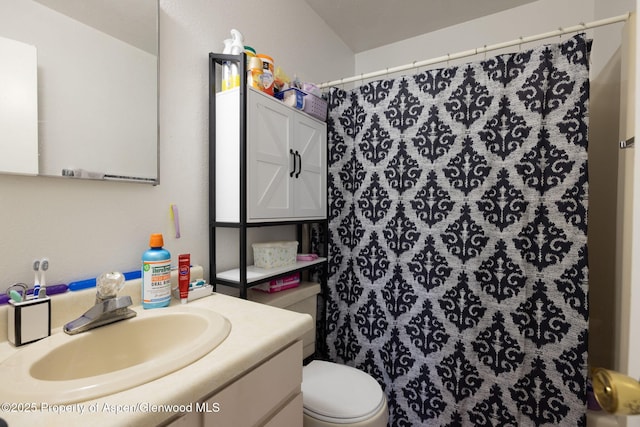 bathroom with vanity, toilet, and curtained shower