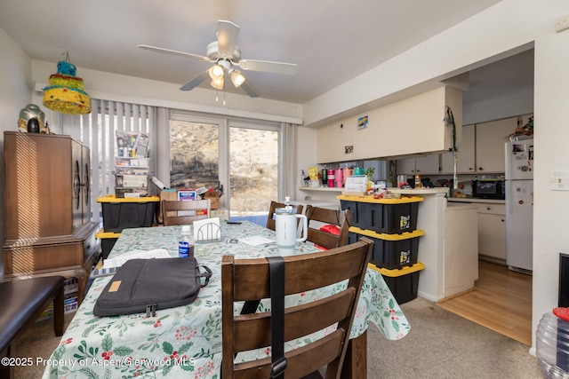 carpeted dining room with ceiling fan