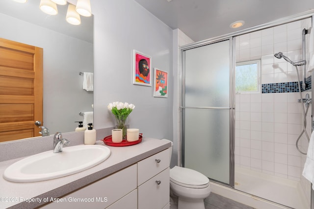full bathroom with a stall shower, vanity, and toilet