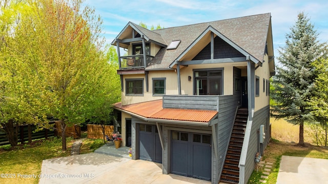 view of front of house with a balcony, concrete driveway, a garage, fence, and roof with shingles