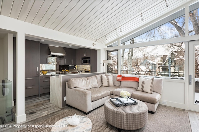 living room with plenty of natural light, lofted ceiling, wooden ceiling, and light hardwood / wood-style flooring