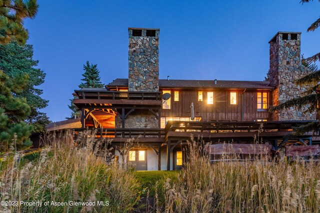 back house at dusk with a deck