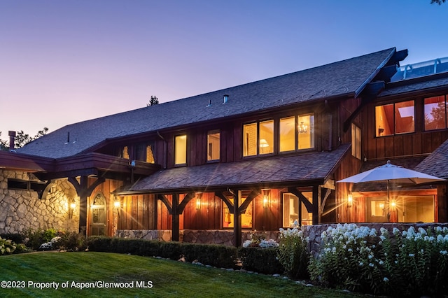 back house at dusk with a yard