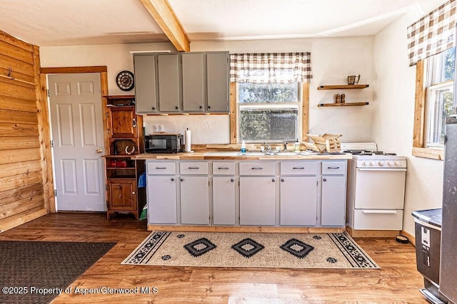 3547 Timberlane Dr Lot 586, Craig, CO 81625 - kitchen with white gas range, black microwave, wood finished floors, a sink, and gray cabinetry
