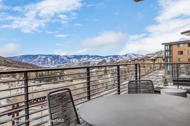 snow covered back of property with a mountain view