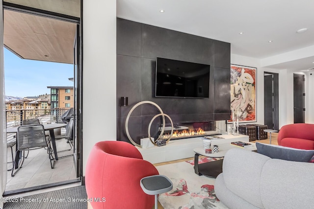 living room with a fireplace and a wall of windows