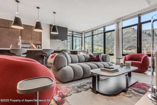 living room with floor to ceiling windows, wooden walls, and plenty of natural light