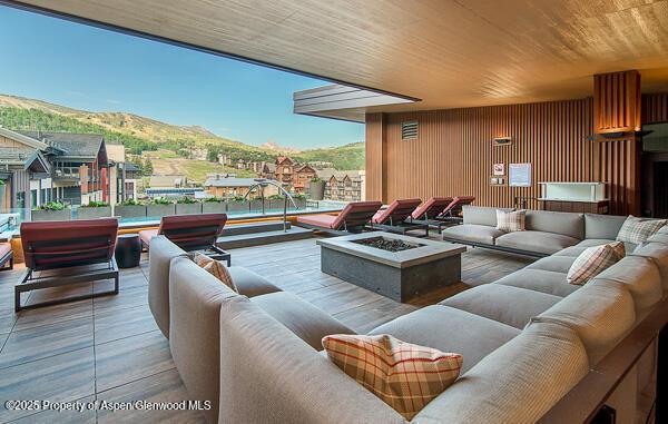 interior space with a mountain view, wooden ceiling, and wood walls