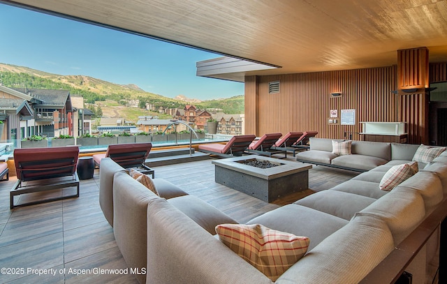 interior space featuring a mountain view, hardwood / wood-style floors, wooden ceiling, and wood walls