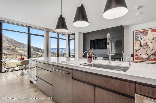 kitchen with pendant lighting, sink, and light wood-type flooring