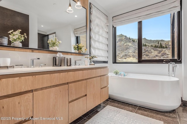 bathroom featuring a bathing tub, a mountain view, and vanity