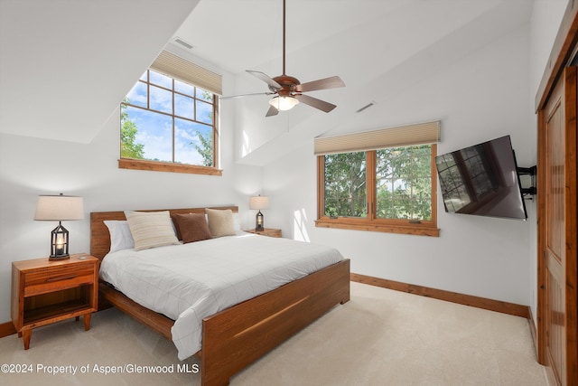 carpeted bedroom featuring ceiling fan, a closet, and vaulted ceiling