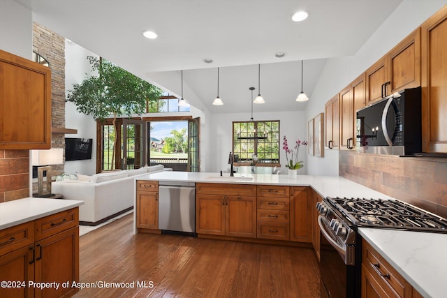 kitchen featuring backsplash, decorative light fixtures, sink, and appliances with stainless steel finishes