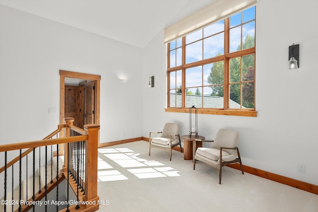 living area with carpet flooring, a wealth of natural light, and lofted ceiling