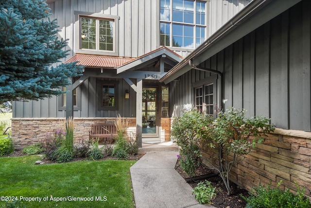 property entrance with a lawn