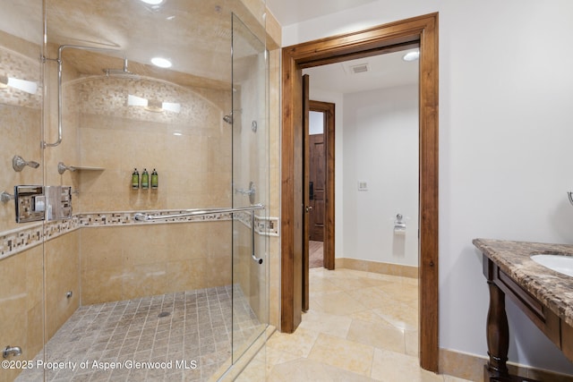 bathroom featuring vanity and a shower with door