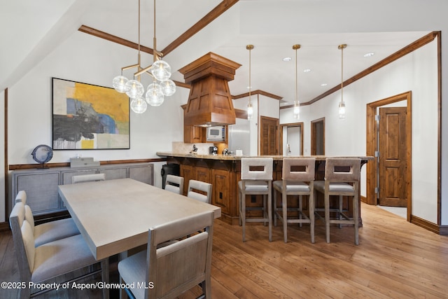 dining room featuring ornamental molding and light wood-type flooring