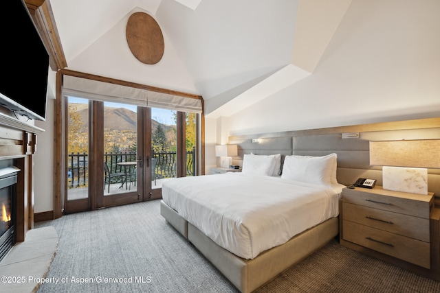 bedroom with lofted ceiling, carpet floors, a mountain view, access to outside, and french doors