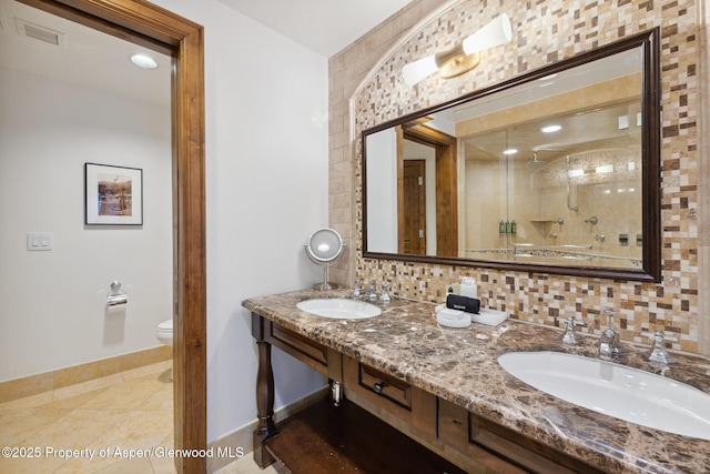 bathroom featuring tile patterned floors, toilet, an enclosed shower, vanity, and decorative backsplash