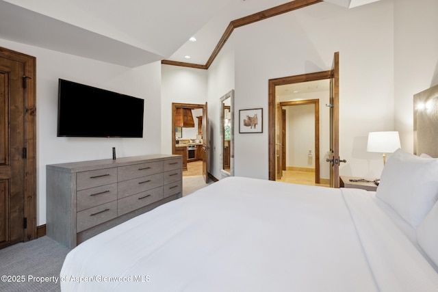 carpeted bedroom with ensuite bathroom and high vaulted ceiling