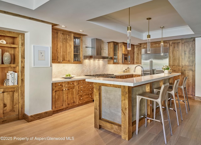501 E Dean St Unit F-502, Aspen, CO 81611 - kitchen featuring wall chimney range hood, brown cabinets, recessed lighting, and crown molding