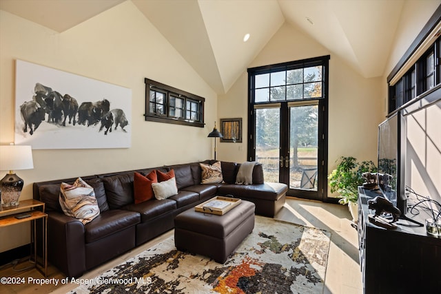 living room featuring high vaulted ceiling and french doors