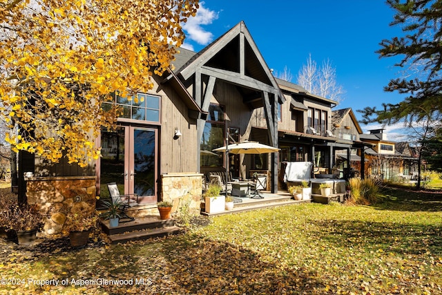 back of house with a lawn, french doors, a balcony, and a patio