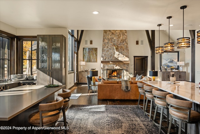 kitchen featuring a fireplace, a kitchen breakfast bar, decorative light fixtures, and dark hardwood / wood-style floors