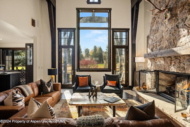 living room featuring a fireplace, a towering ceiling, and a wealth of natural light