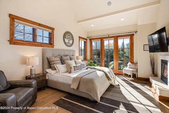 bedroom featuring french doors, light wood-type flooring, and lofted ceiling