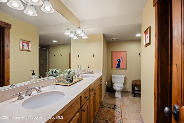 bathroom with tile patterned floors, vanity, toilet, and walk in shower