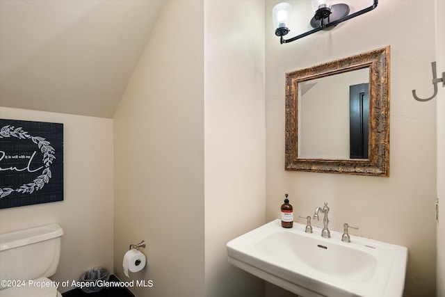 bathroom with sink, vaulted ceiling, and toilet