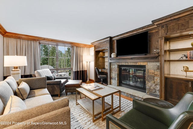 living room with built in shelves, a stone fireplace, and ornamental molding