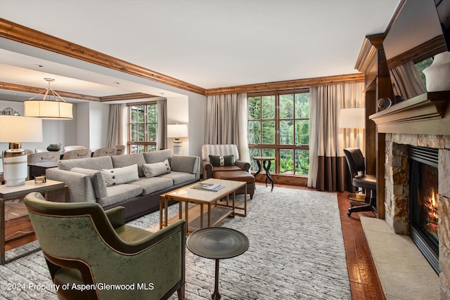 living room featuring a fireplace, hardwood / wood-style floors, plenty of natural light, and ornamental molding