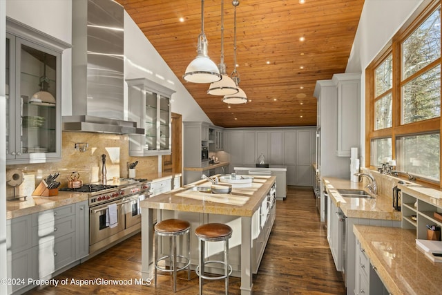 kitchen with wall chimney exhaust hood, double oven range, lofted ceiling, a kitchen island with sink, and wood ceiling