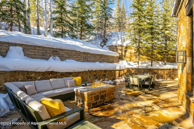 snow covered patio featuring an outdoor living space